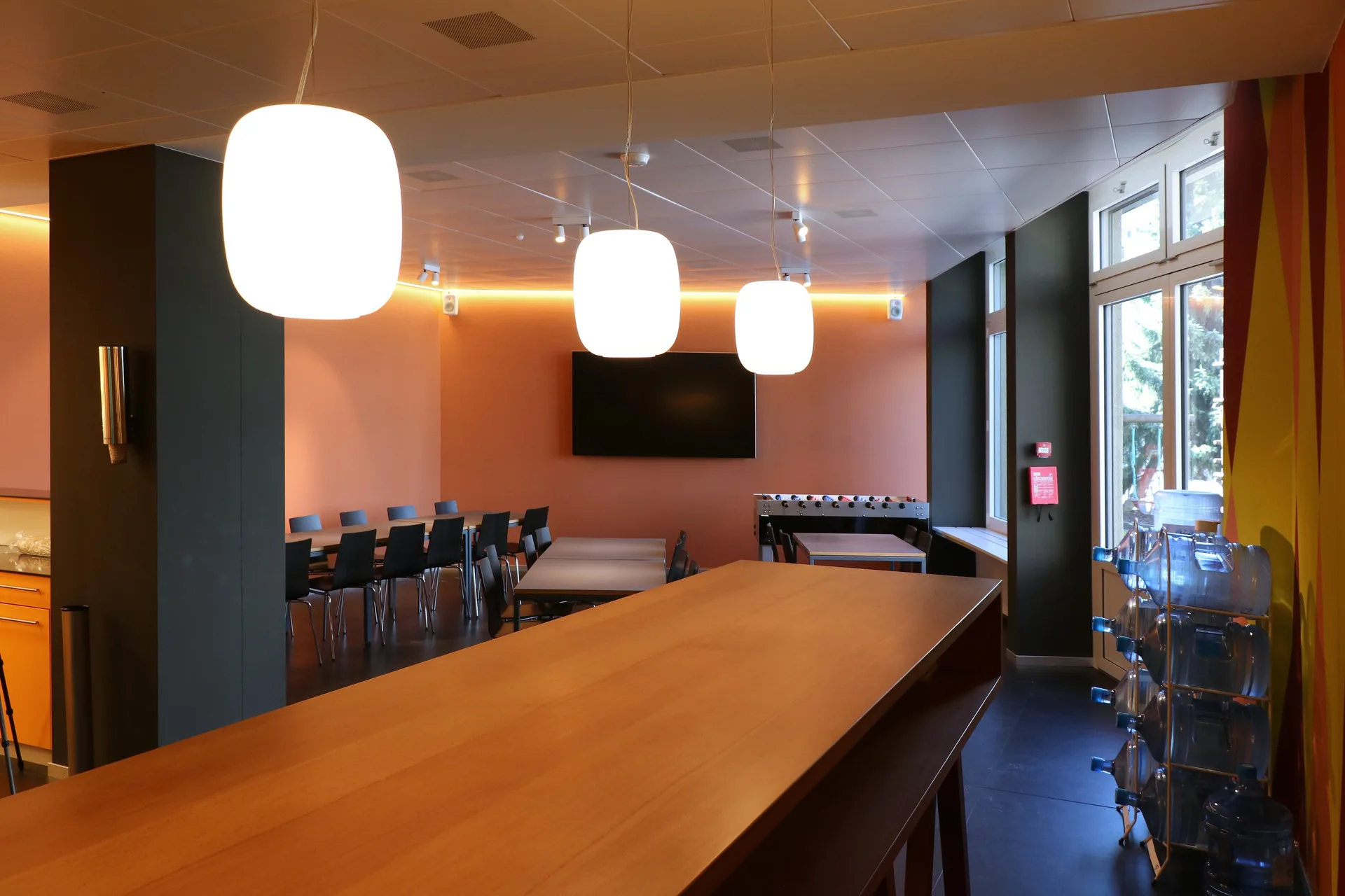 Cafeteria mit Holztisch und Kugelleuchten