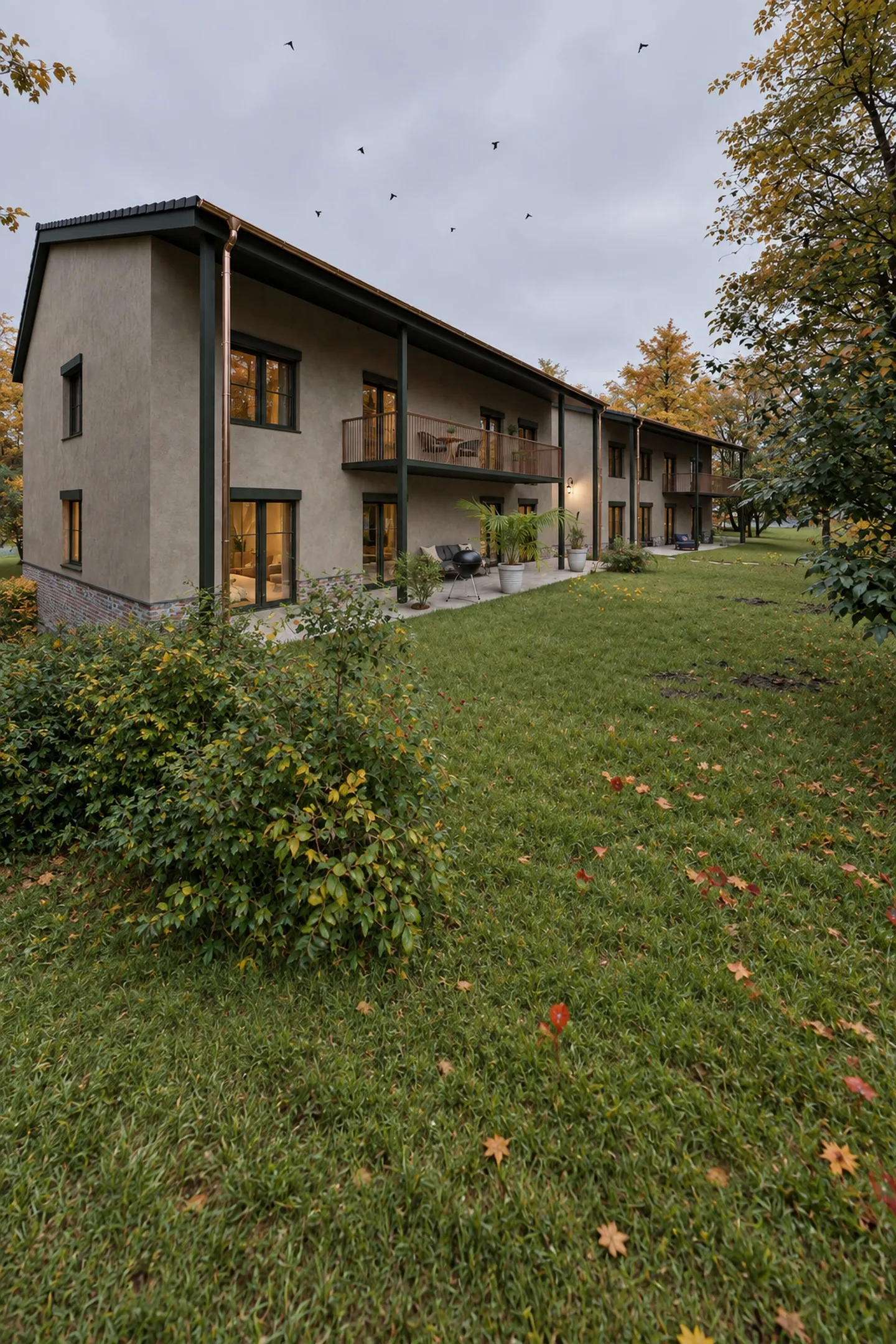 Gartenfassade am Abend mit durchgehendem Balkon