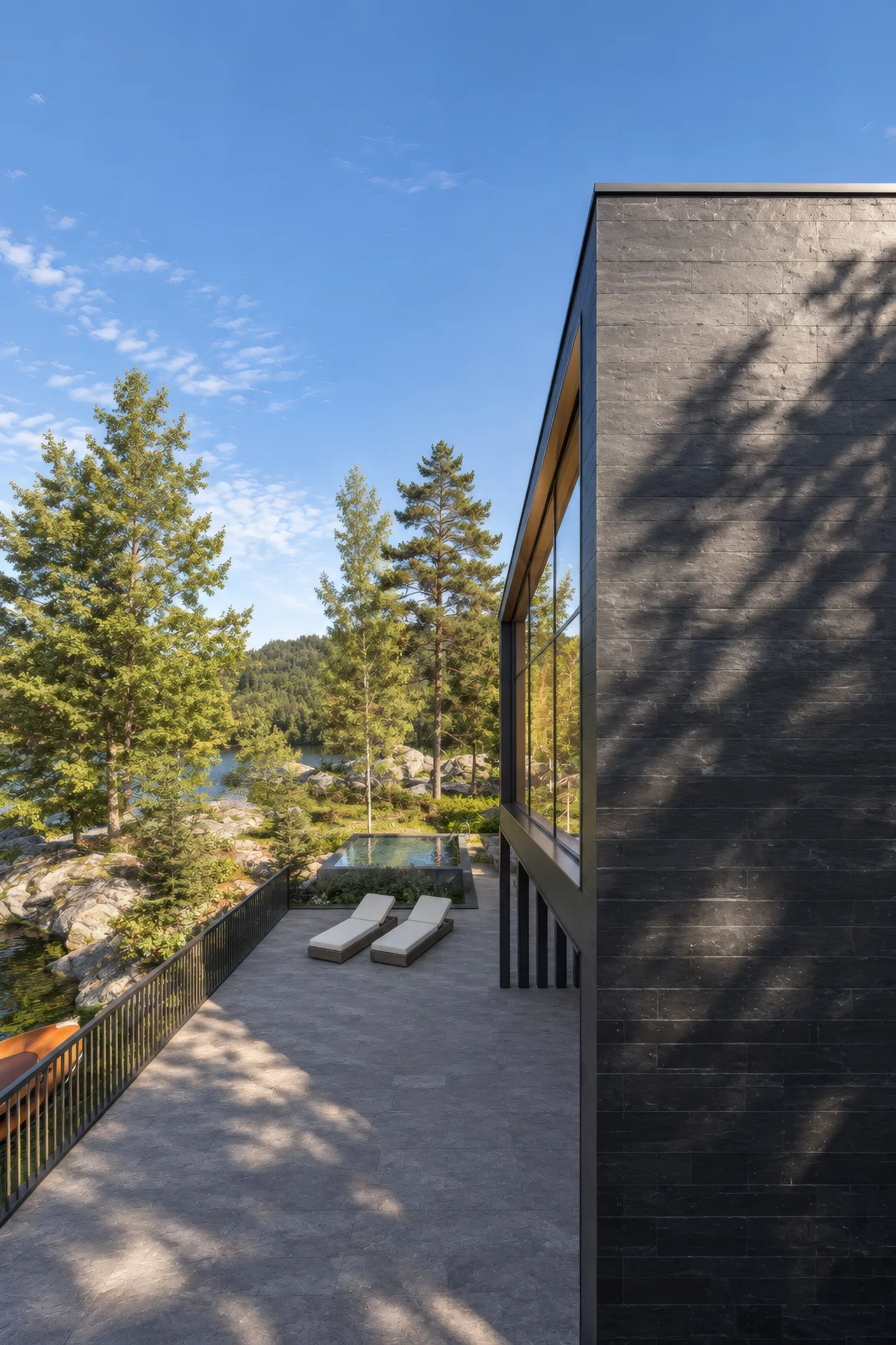 Terrasse mit Liegen und Pool, daneben die dunkle Holzfassade