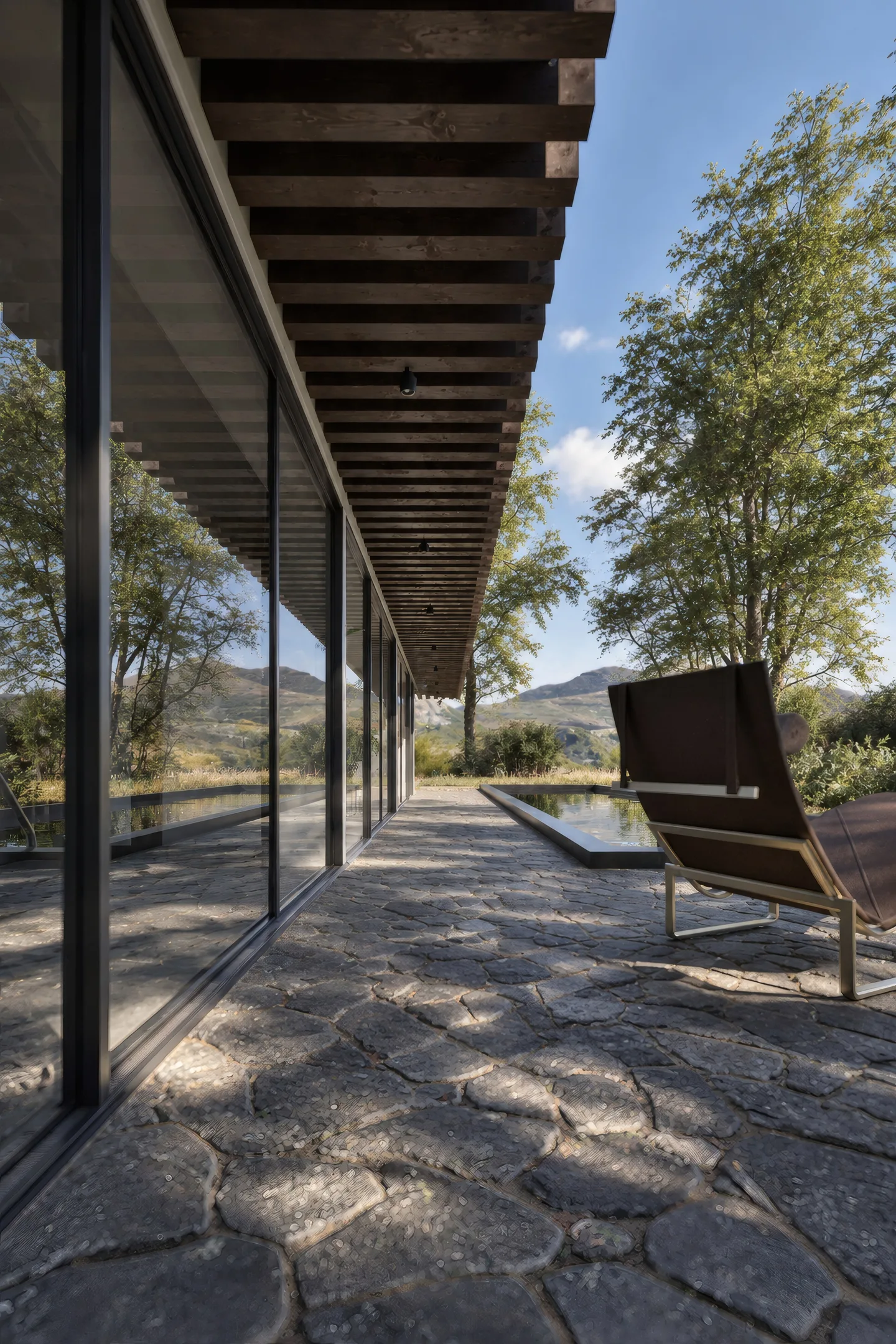 Terrasse mit Liegestuhl unter dem auskragenden Obergeschoss