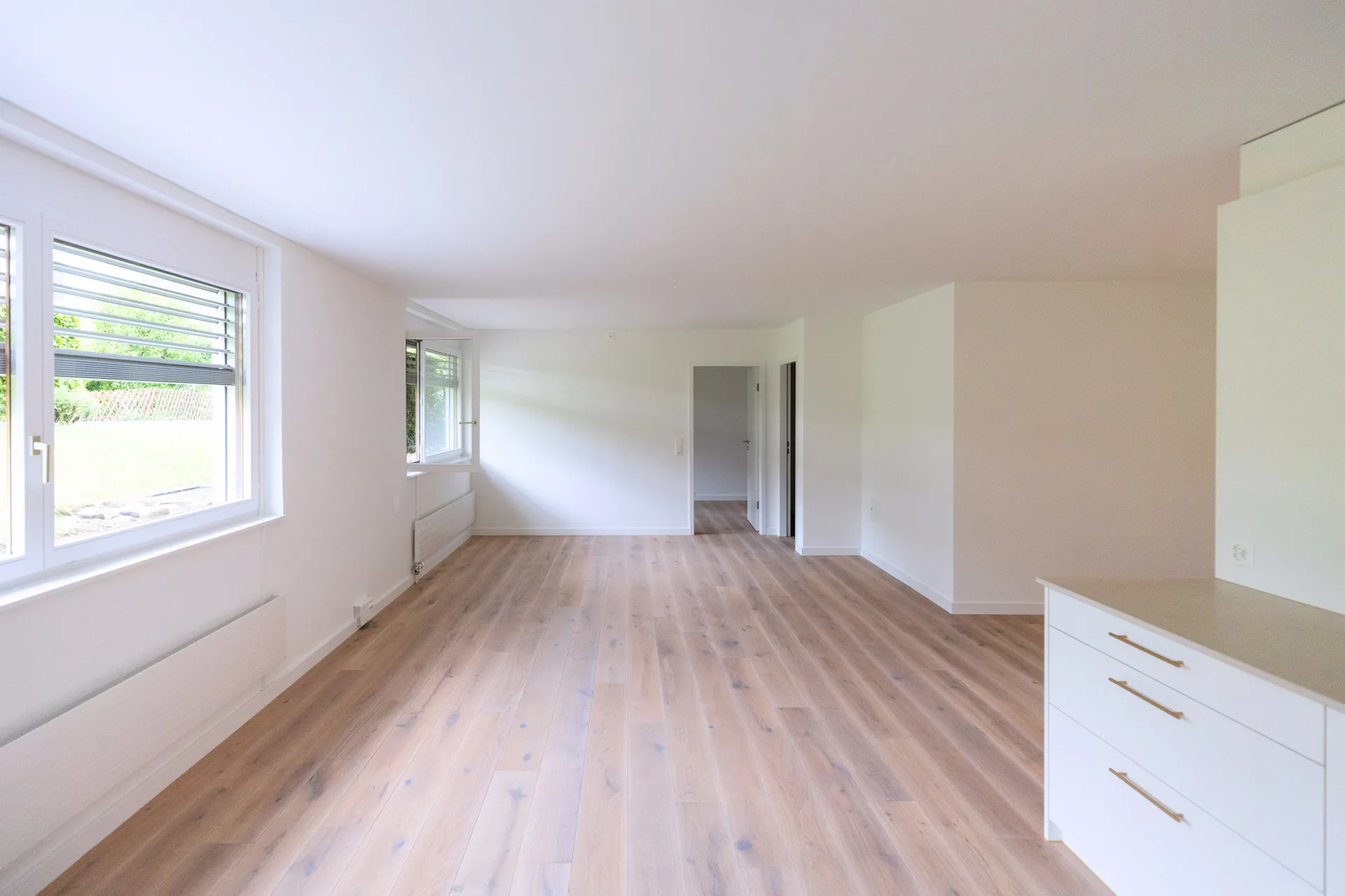 Wohnbereich mit Fensterband und Blick zur Küche