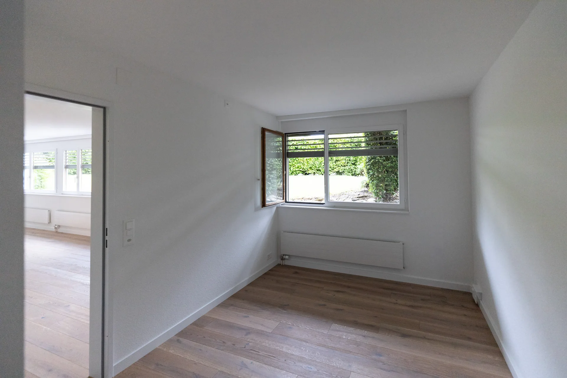 Zimmer mit Eckfenster, Blick durch die Tür in den Wohnbereich
